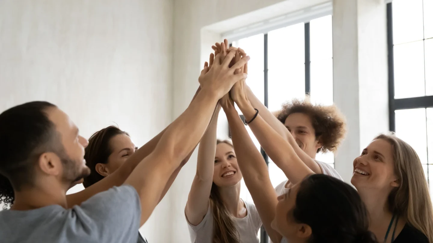 Group of people celebrating by holding hands