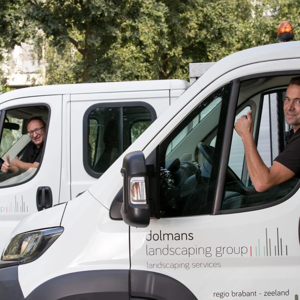 2 man sitting in 2 different vans looking at the camera.