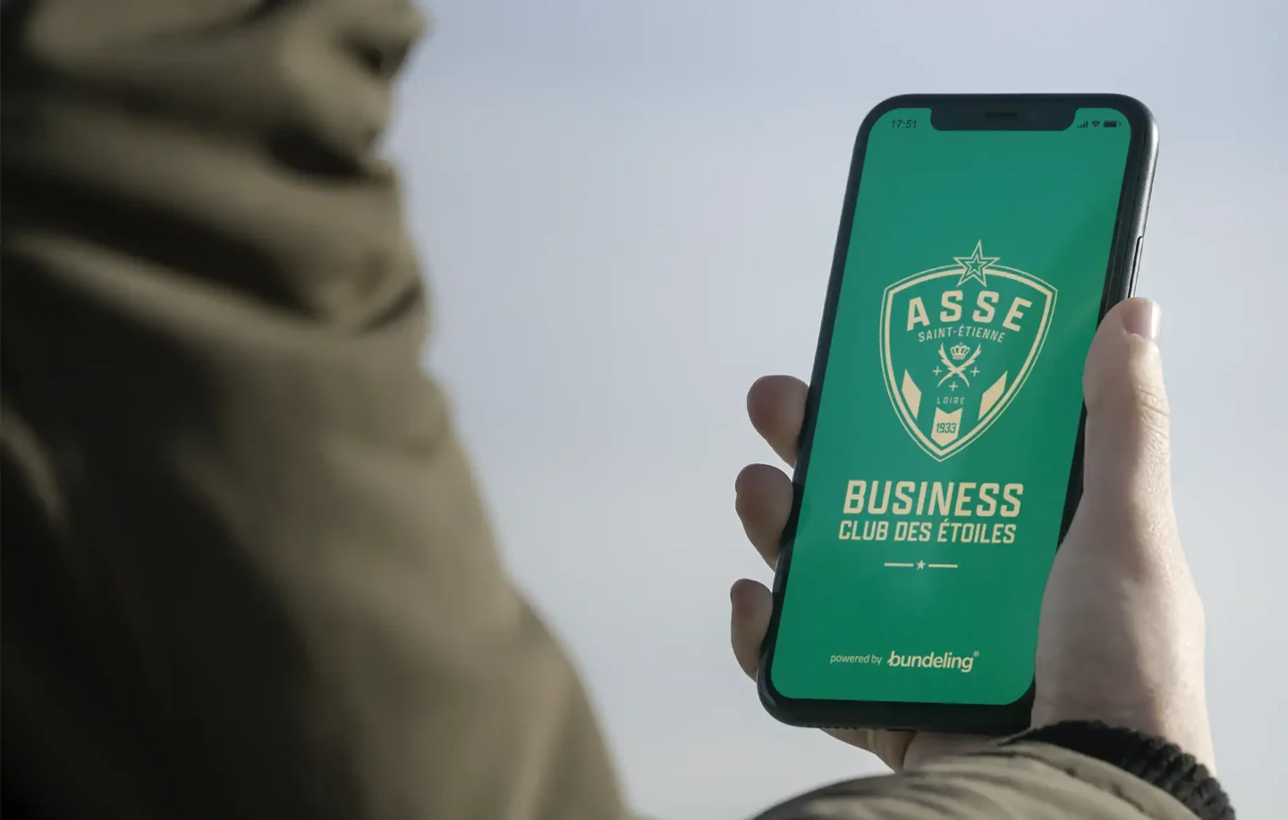 A hand holding the Bundeling Saint Etienne app