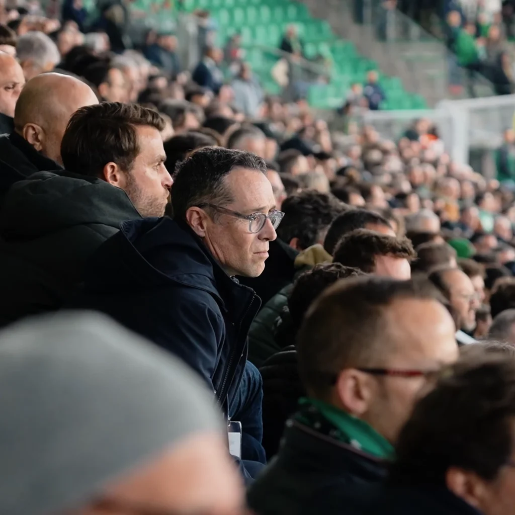 Man sitting in a crowd in a football stadium