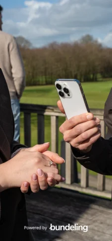 A golf course with a hand holding a modern iPhone