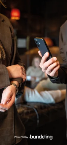 A fancy looking business room with a hand holding a modern iPhone