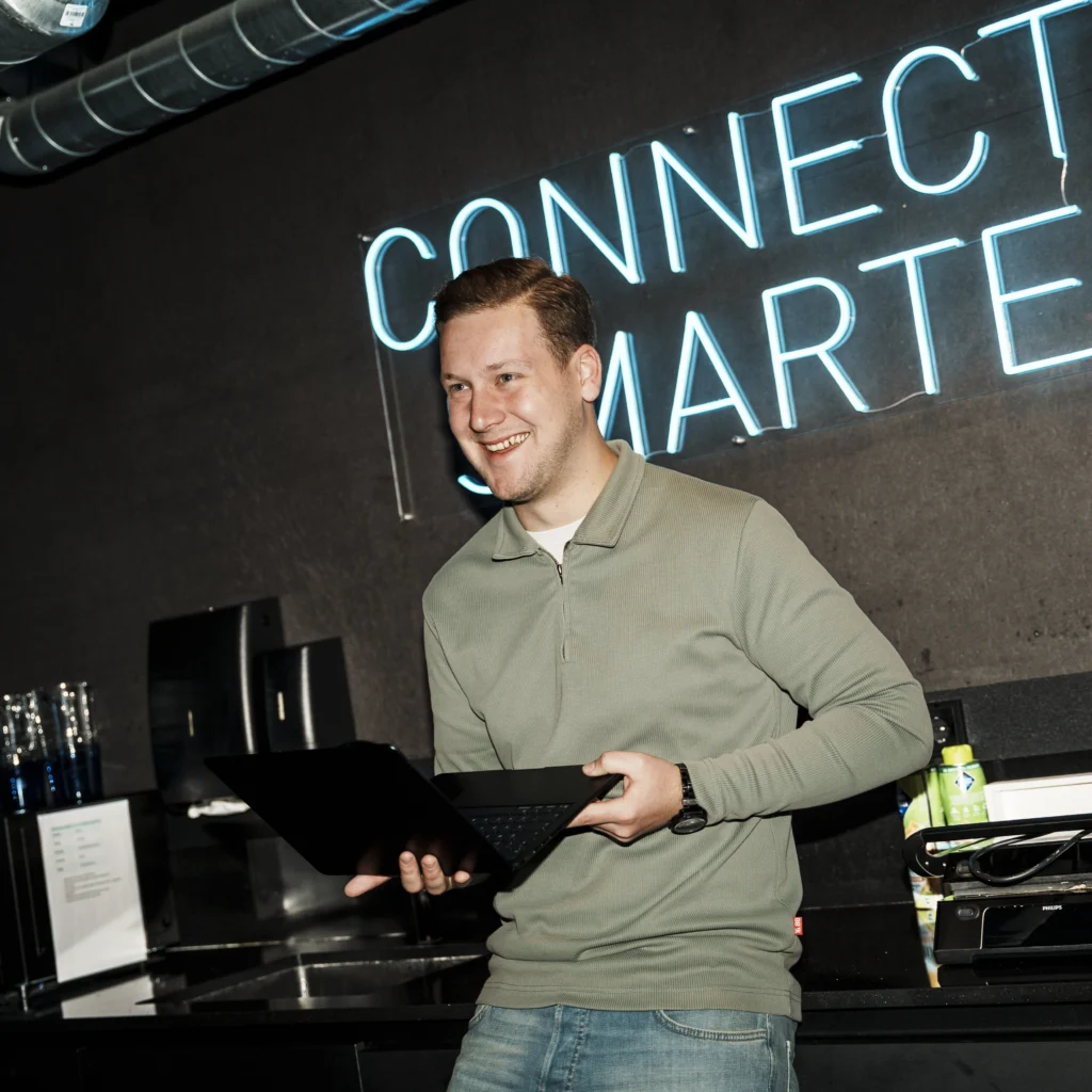 Laughing young man with laptop in his hands.