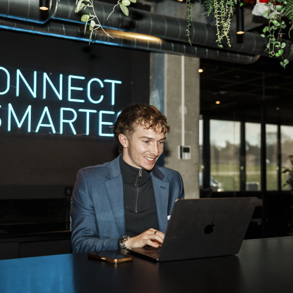 Young smiling man using a laptop.