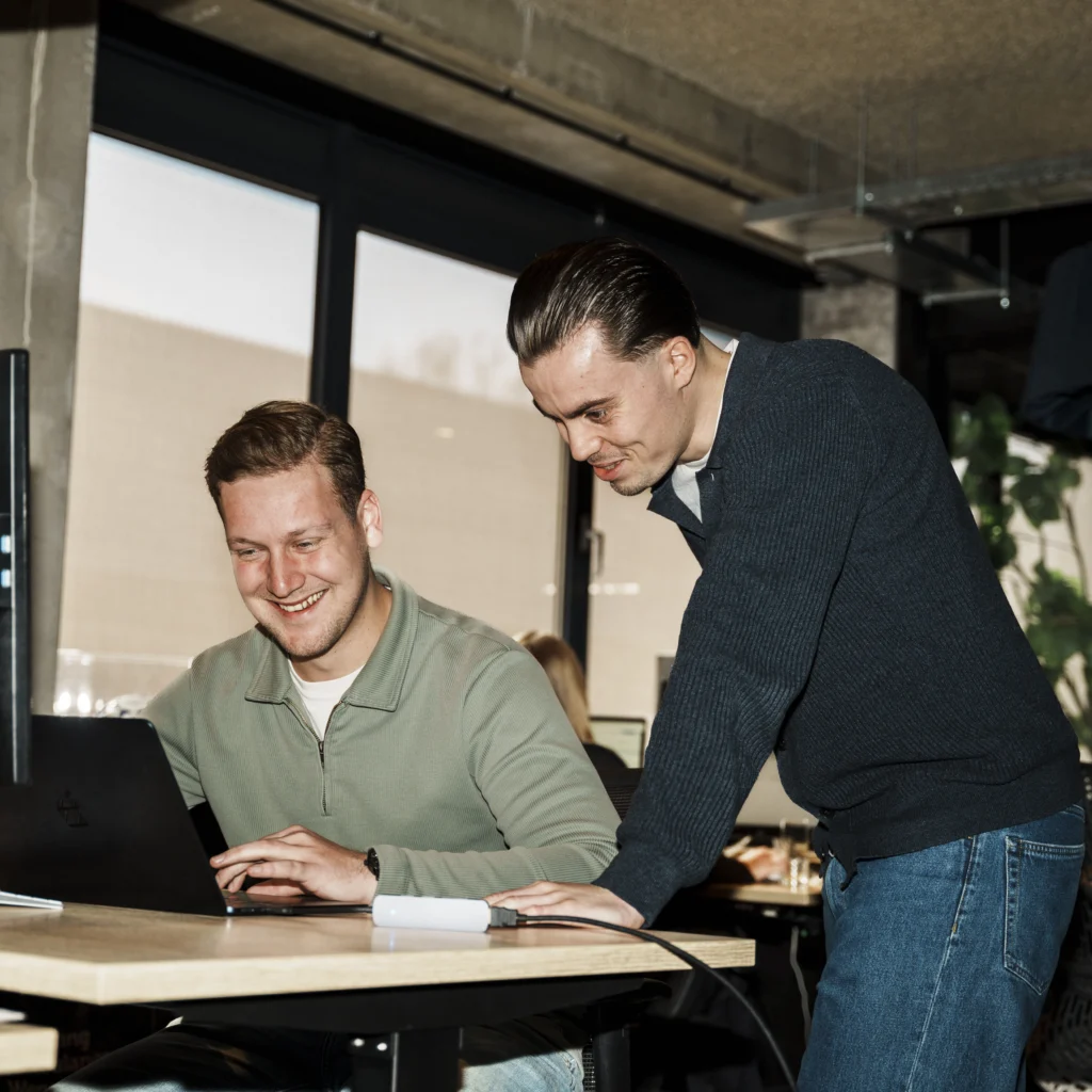 2 guys in a office setting working together.