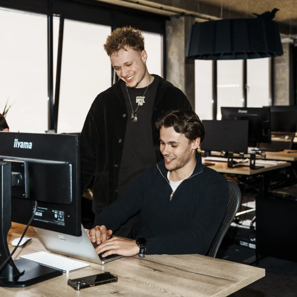Office setting with 2 young guys working.