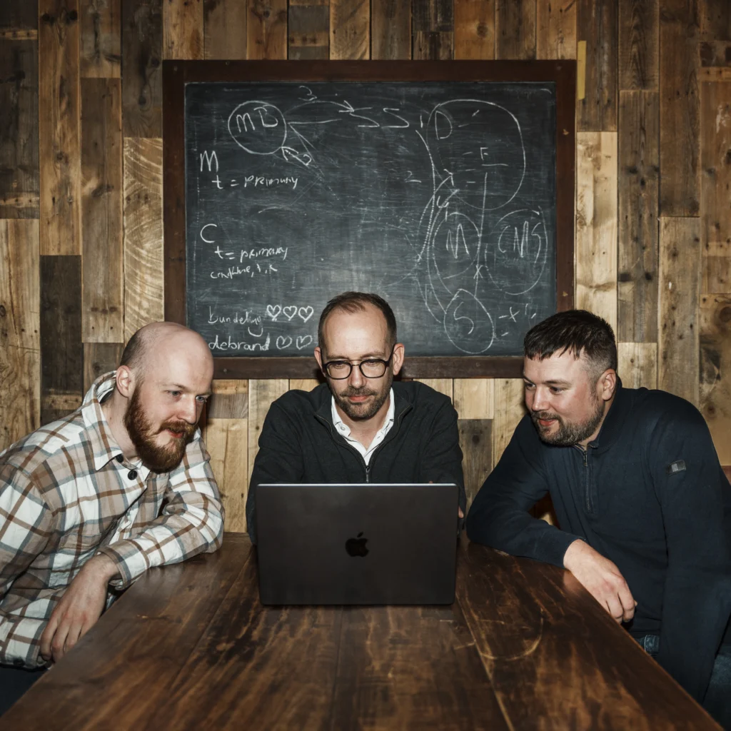 Three serious men sitting in a meeting together.
