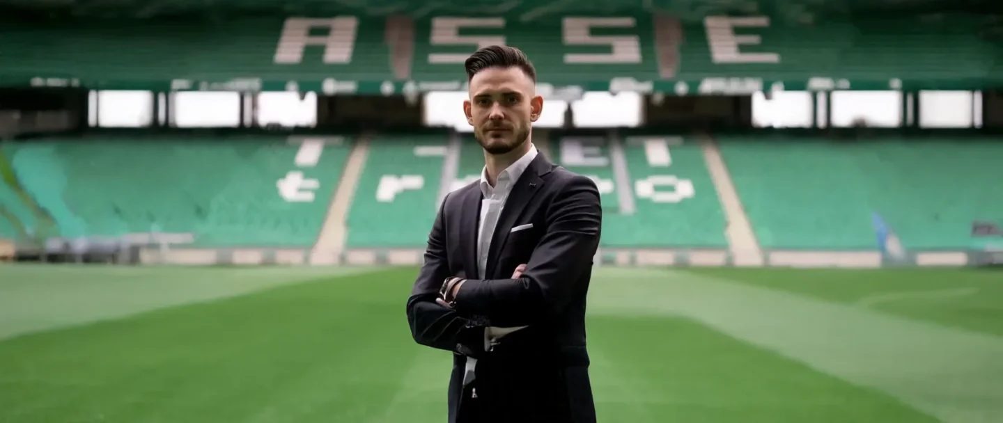 Man in suit standing on the pitch of a football stadium