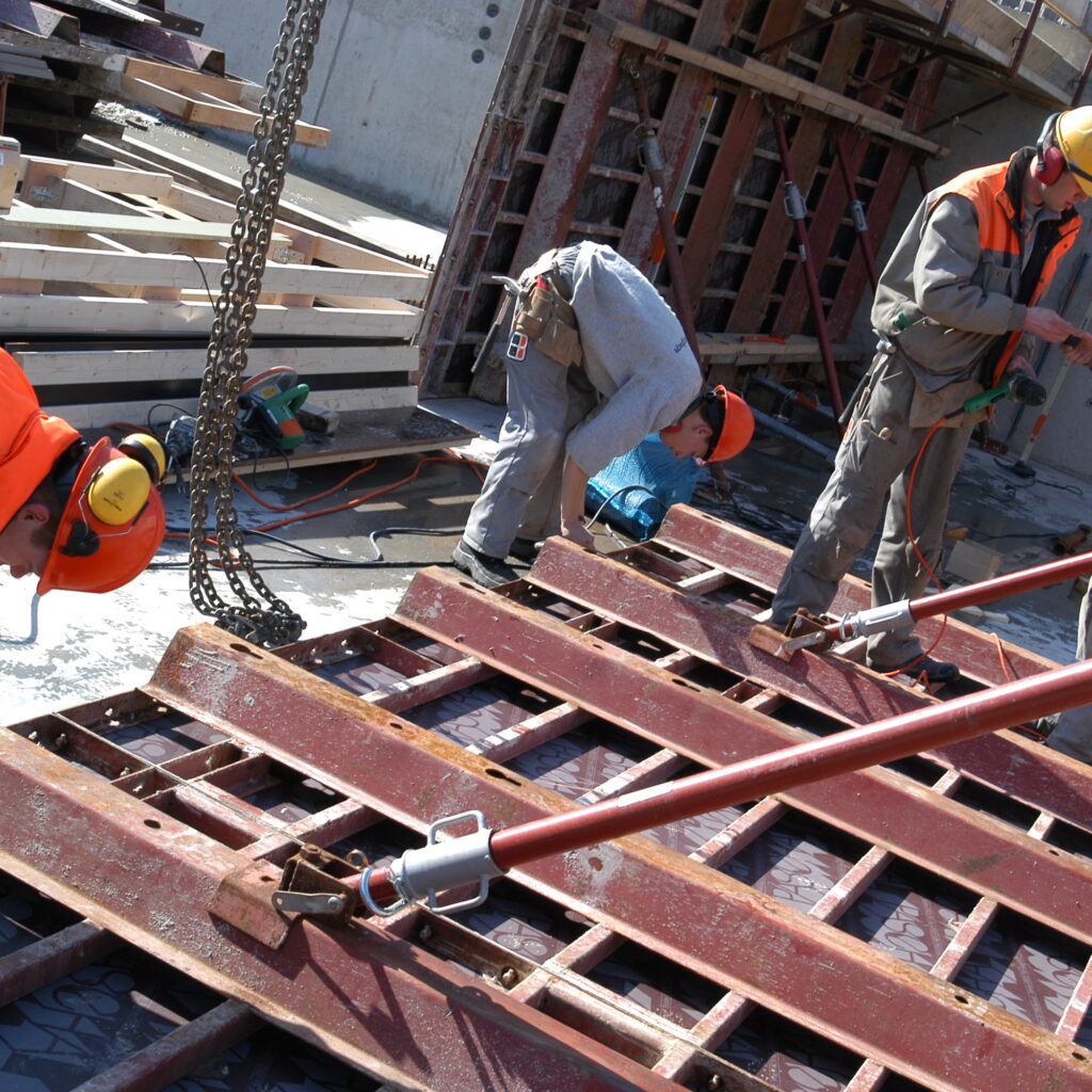 Mannen op een bouwplaats aan het werk met een ijzeren constructie